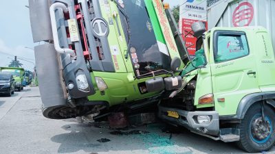 Masuk ke Irigasi, Truk Bermuatan Batu Timpa Mobil Truk yang Sedang Parkir di Jalan Raya Gunung Putri